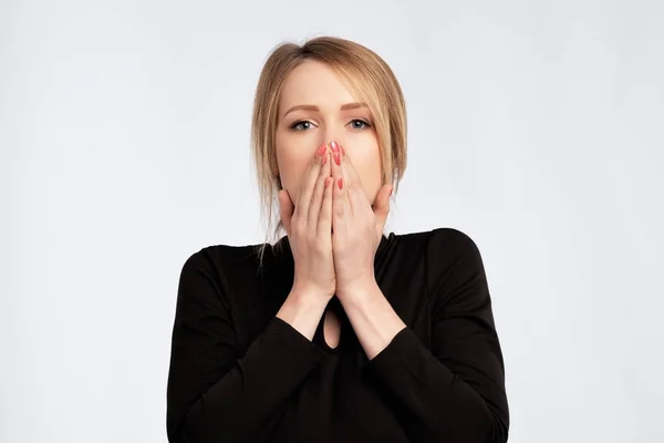 Caucasian sad surprised excited woman in black dress covering with hands her mouth with blank copyspace. — Stock Photo, Image