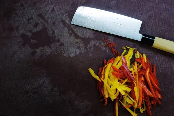 Mesa con cuchillo y pimienta cortada. vista superior de los utensilios de cocina y verduras frescas — Foto de Stock