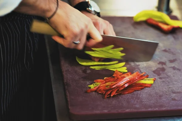 Pria kaukasia memotong paprika dengan pisau besar . — Stok Foto