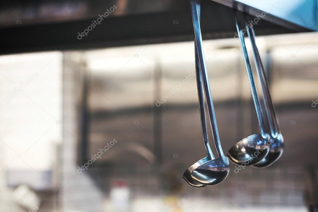 A lot of soup ladles hanging in kitchen.