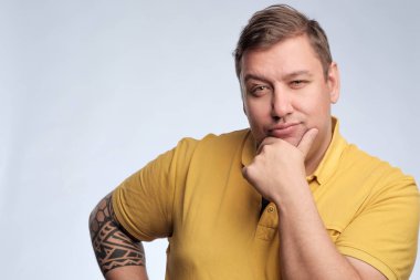 Sarı tişört Studio gri arka plan üzerinde poz içinde şişman bir beyaz adam portresi.