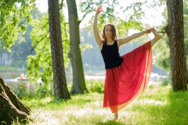 Kafkas kadın kırmızı etek denge yoga asana yaz Park yapıyor.