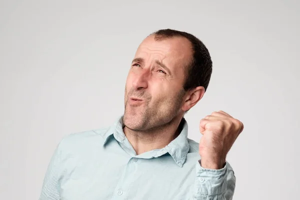 Gelukkige gelukkig volwassen Spaanse mannelijke winnaar riep, vreugde op zijn succes op het werk, ja zeggen, balde vuist en ogen sluiten — Stockfoto