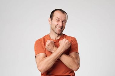 Onun güç ve dayanıklılık gösteren mutlu olgun adam kollarını göğüs önünde geçiş.