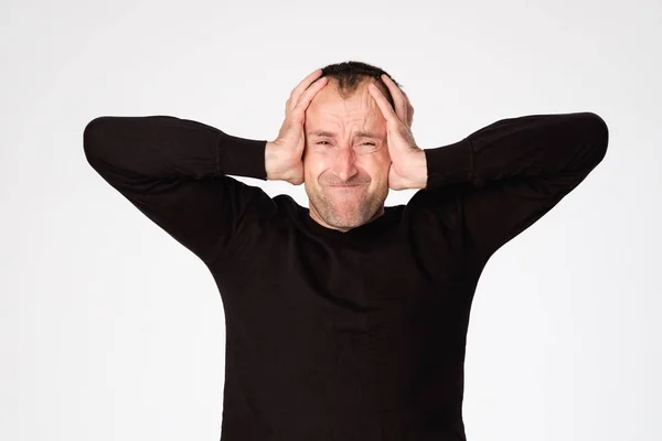 Volwassen Spaanse man zijn oren sluiten vanwege hoofdpijn of migraine — Stockfoto