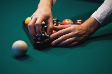 Bilardo oynarken. Bilardo topları yeşil Bilardo masasında. Beyaz oyuncu topu koymak. Taraftan göster.