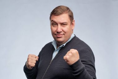 Kameraya bakarak katlanmış silah ile kendine güvenen orta yaşlı adam portresi yarım vücut