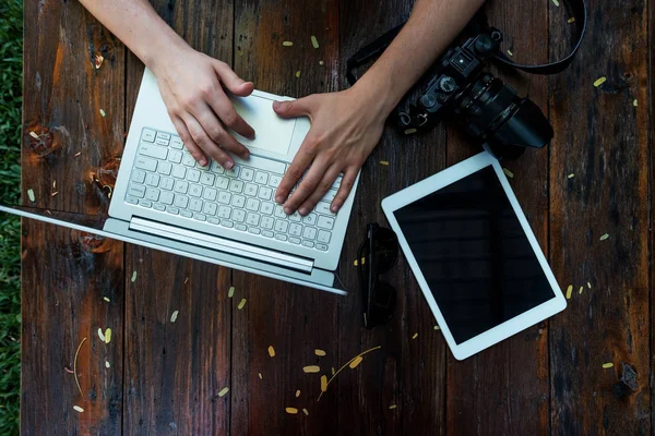 Laptop, kamera på trä bakgrund. Platt låg av arbetsplats frilansare eller enskilda företagare — Stockfoto