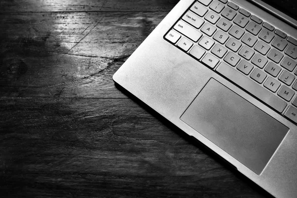 Крупный план клавиатуры ноутбука на деревянном темном фоне — стоковое фото