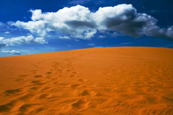 Φωτεινό κίτρινο άμμο αδειάζει κατά το γαλάζιο του ουρανού με σύννεφα. — Φωτογραφία Αρχείου
