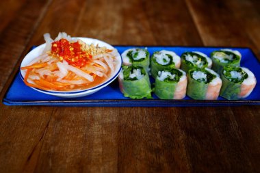 Mavi plaka üzerinde sebze ve pirinç kağıdı soslu taze bir ekmek