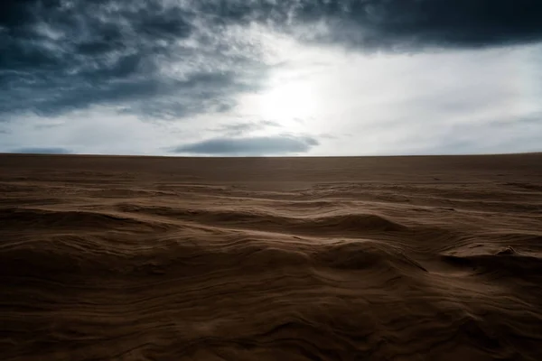 Dune sabbiose con cielo nuvoloso scuro — Foto Stock