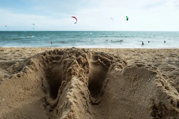 Cerca de un hombre pies rastros en la playa de arena cerca de la orilla del mar . —  Fotos de Stock