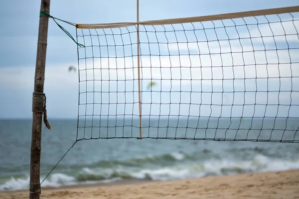 Ein Beachvolleyballnetz am Strand in der Nähe von Meerwasser — Stockfoto
