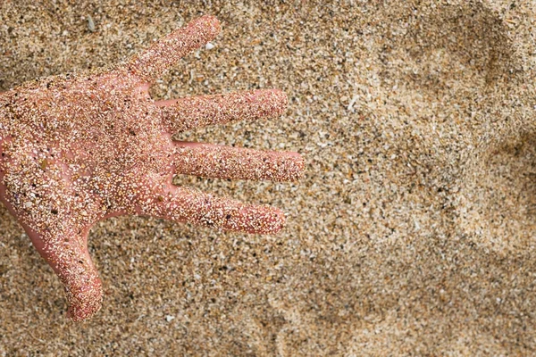 Uma mão caucasiana na areia na praia — Fotografia de Stock