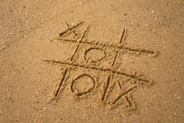 Tic-tac-toe desenho em fundo de areia . — Fotografia de Stock