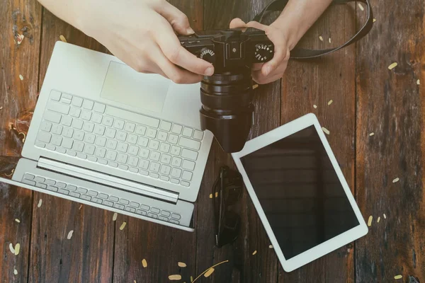 流行に敏感なビンテージ木製デスクトップ トップ ビュー、男性の両手の写真を見て photocamera. — ストック写真
