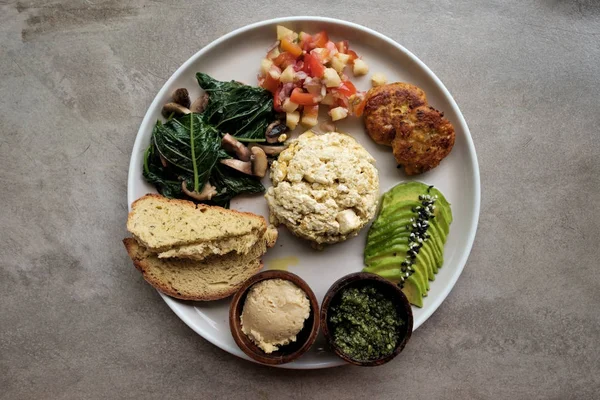 Веганский тофу с авокадо, хлеб, овощи и источник крупным планом на тарелке . — стоковое фото