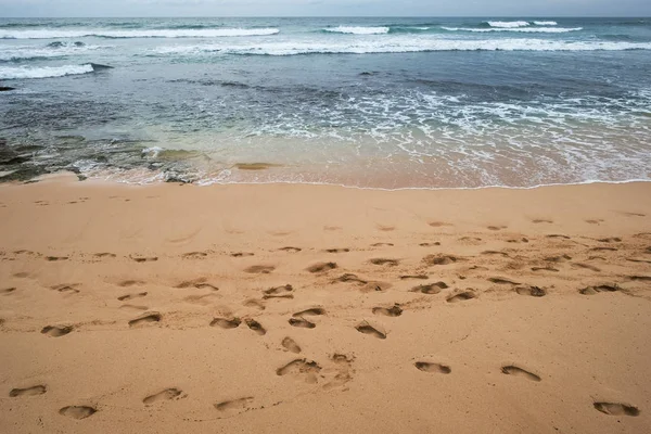 Una gran cantidad de huellas o rastros en la playa de arena o costa en vacaciones —  Fotos de Stock