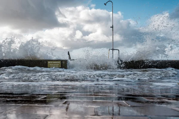 Salpicadura de una ola en el terraplén inundado cerca del mar . — Foto de Stock