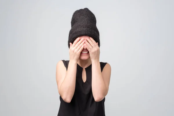 Frau schließt die Augen mit der Hand, hat einen glücklichen Gesichtsausdruck, nimmt Geschenke entgegen — Stockfoto