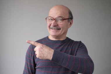 Kendinden emin İspanyol kıdemli bir adam işaret ediyor. Ciddi olgun bir erkek parmağını bir kenara koyuyor.