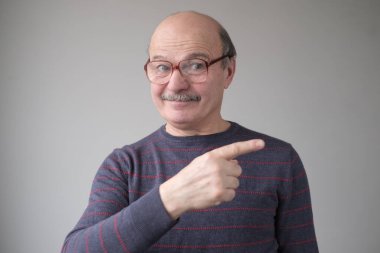 Kendinden emin İspanyol kıdemli bir adam işaret ediyor. Ciddi olgun bir erkek parmağını bir kenara koyuyor.