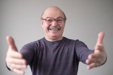 Baba kameraya doğru elini çekiyor, sarılmak istiyor.