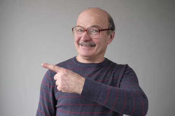 Confident hispanic senior man point aside. Serious mature male gesturing with his finger aside — Stock Photo, Image