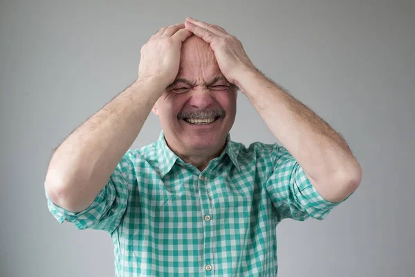 Denken Kaukasische senior man houdt handen op het hoofd. — Stockfoto