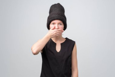 Kahkahalar atan siyah şapkalı beyaz kadın ağzını eliyle kapatıyor.