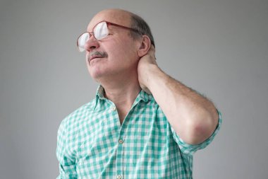 Beyaz, boynu ağrıyan olgun bir adam..