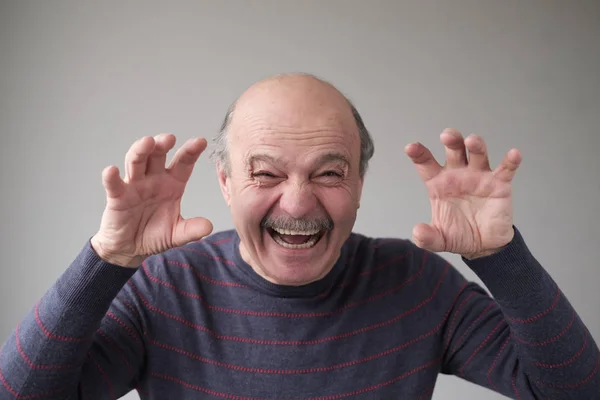 Homme hispanique senior avec le visage effrayant grimaçant pour vous effrayer — Photo