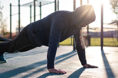 Spor, egzersiz, eğitim konsepti. Şınav çeken genç bir adam ya da tahta egzersizi.