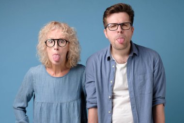 Heyecanlı, eğlenceli, komik, neşeli adam ve kadın çubuk dil çıkarıyorlar..