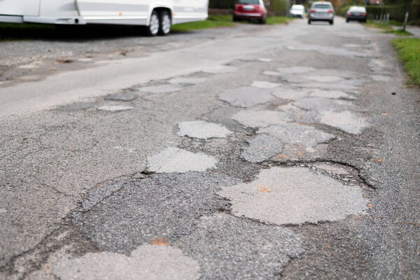 Holes and damaged road in small town of Germany