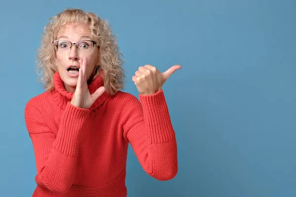 Blond blank dame bedekken mond met de hand vertelt geheimen aan iemand — Stockfoto