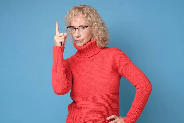 Серйозна жінка в окулярах вказує індексний палець, даючи пораду . — стокове фото