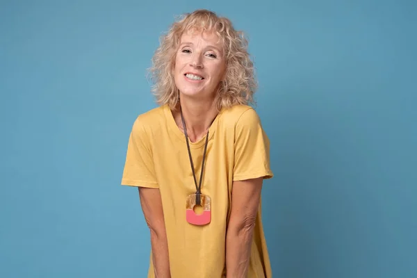 Belle femme d'âge moyen avec des cheveux blonds sur un fond bleu — Photo