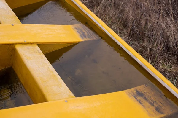 Agua congelada en barco amarillo roto en la orilla del río . — Foto de Stock