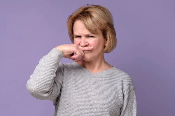 Grand-mère se rafraîchissant le nez de l'odeur et mauvaise odeur de la cuisine . — Photo