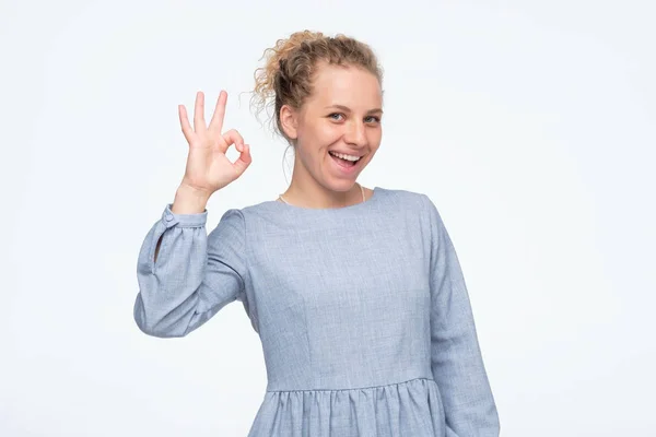 Young caucasian woman in blue summer dress showing ok sign approving choice — 스톡 사진