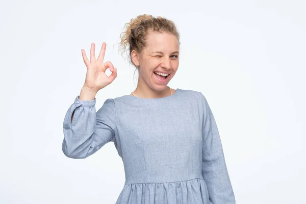 Young caucasian woman in blue summer dress showing ok sign approving choice — 스톡 사진