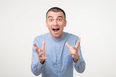 Neşeli İspanyol adam ellerini kaldırıyor, yüzü mutlulukla dolu.