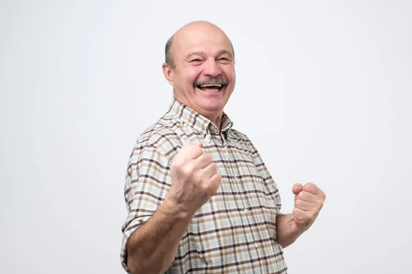 Чоловік середнього віку щасливий і схвильований святкуванням перемоги, що виражає великий успіх — стокове фото