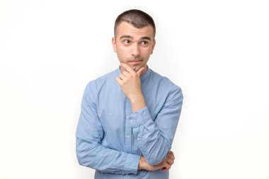 Hispanik genç adam ya bir fikir düşünüyor ya da bir seçim yapıyor..