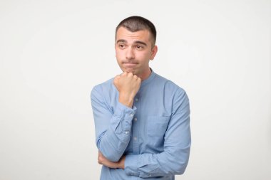 Hispanik genç adam ya bir fikir düşünüyor ya da bir seçim yapıyor..