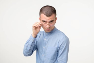 İnançsız bir ifadeyle gözlüklü, şüpheli bir İspanyol..