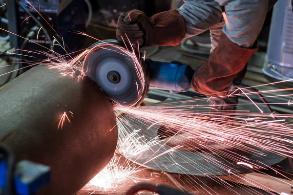 Homem de luvas de proteção corte de metal usando moedor de ângulo fazendo faíscas — Fotografia de Stock