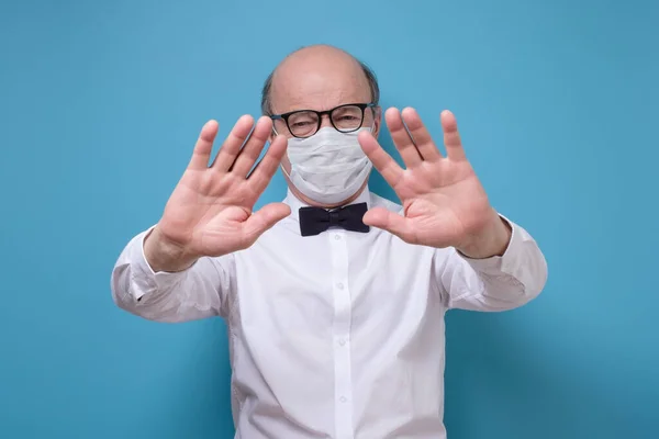 . Senior man showing gesture stop wearing special medical mask — Stockfoto